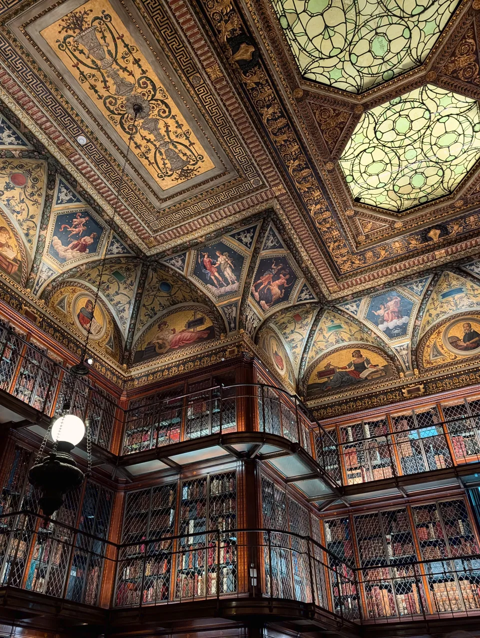 Painted ceilings, glass skylights and tall bookcases at the Morgan Library.